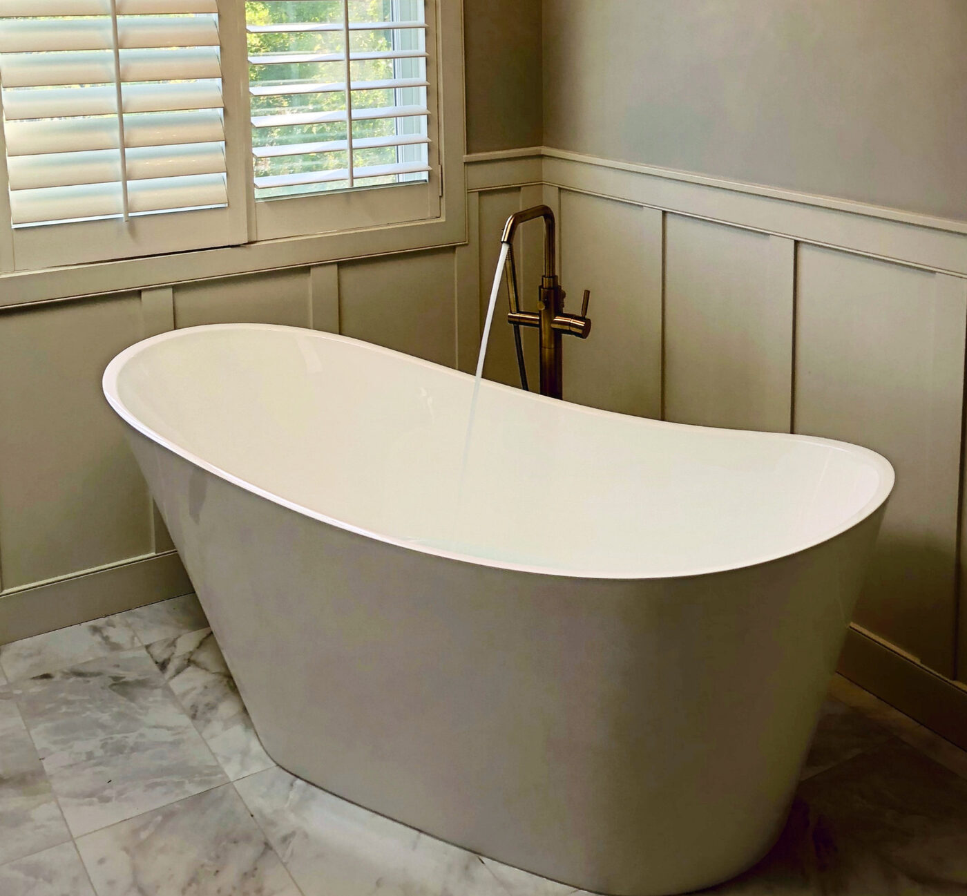 Freestanding tub with floor-mounted brass filler, installed by Daniel